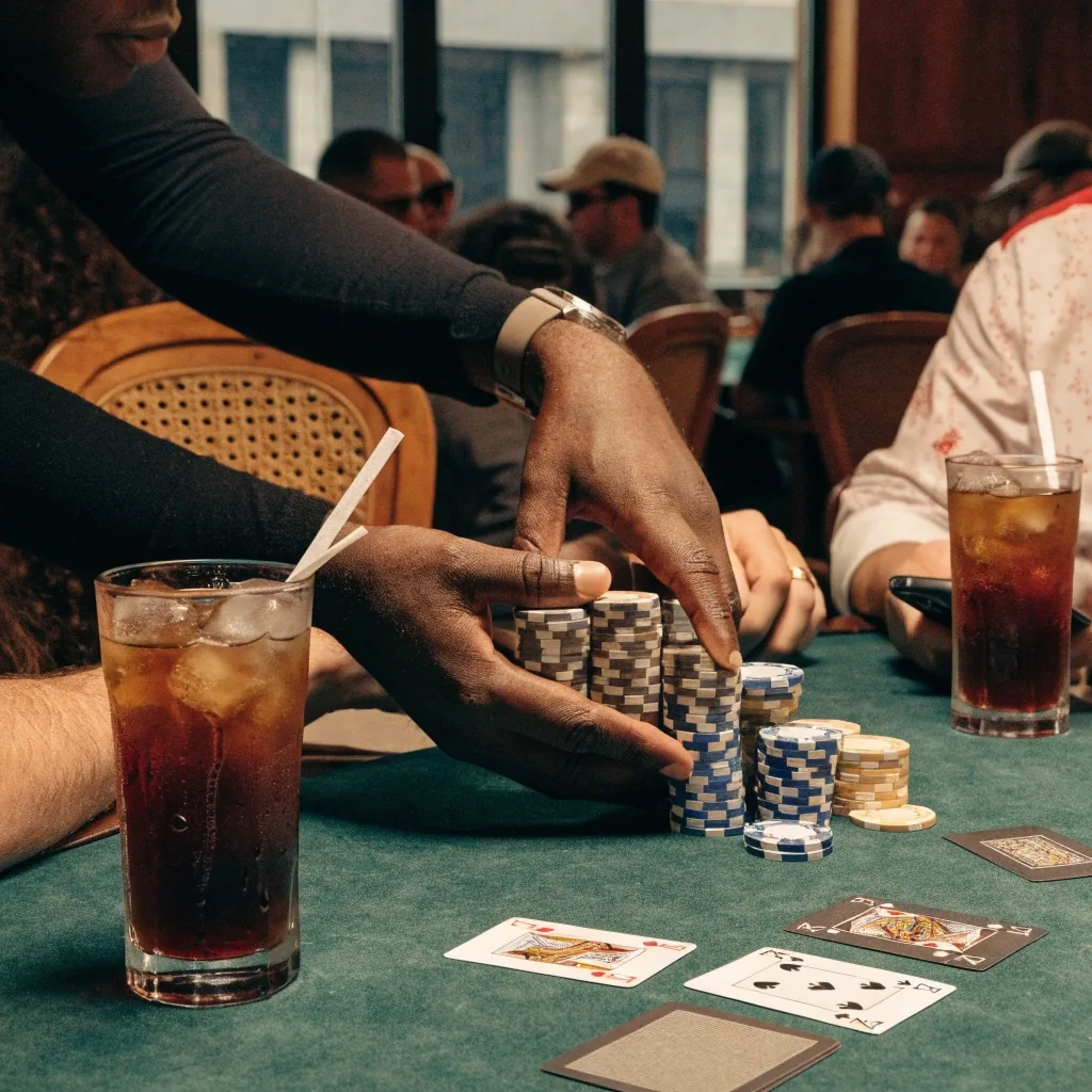 Čtyři karty a nízký kruh žetonů na filcu při hře Pot Limit Omaha